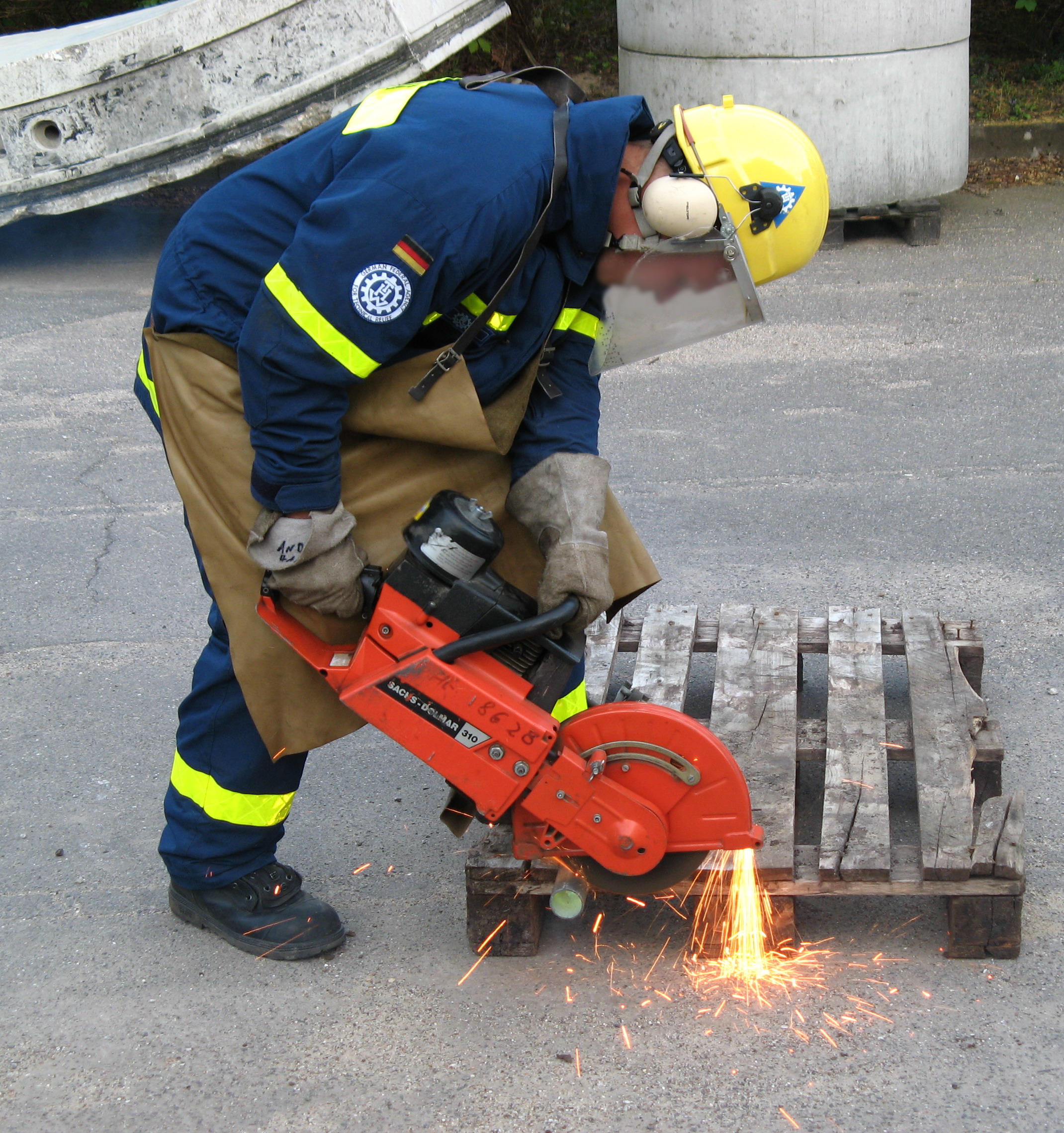 Student using power tools including pillar drill and angle grinder with proper safety equipment