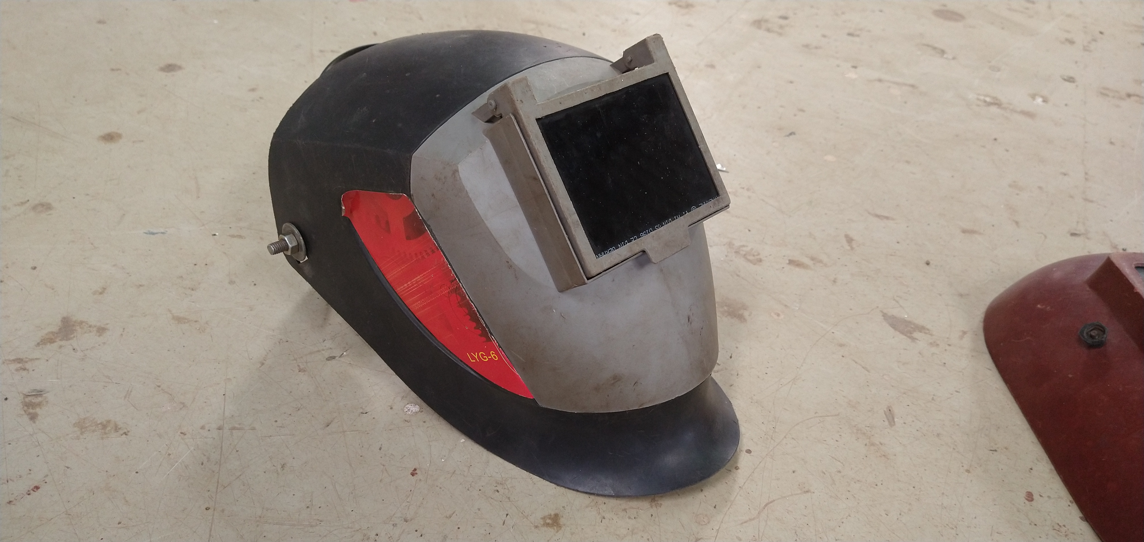 Workshop-provided safety equipment including welding helmets, safety glasses, and hearing protection